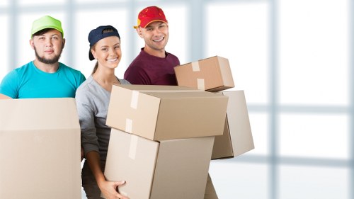 Professional movers carrying furniture from a family house